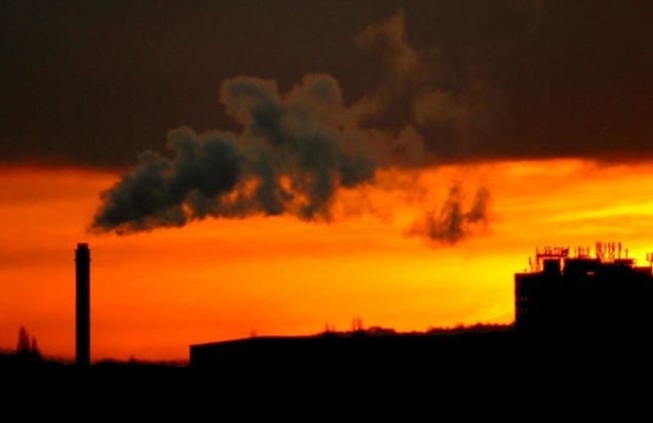 Chimenea contaminante de central al atardecer