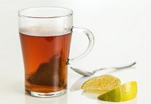 ¿Cuántos millones de microplásticos ingerimos con una taza de té? Vaso con infusión de bolsa de te y rodajas de limón al lado