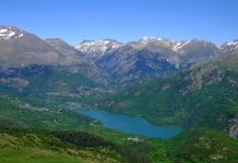 Alarmante calentamiento, menos agua y ecosistemas alterados: los Pirineos están cambiando Paisaje pirenaico con valle verde, montañas nevadas y lago al fondo