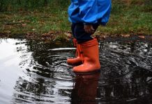 Concurso «Escolares #PorElClima»: en busca de la clave para que los adultos actúen Niño chapotea en charco con botas de agua rojas