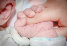 Evidencias de exposición prenatal a ftalatos como causa de autismo Bebé dormido coge dedo de adulto