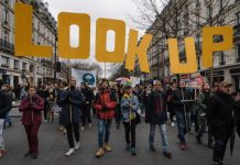 Don’t Look Up y otras nueve películas con temática ambiental para disfrutar Cartel donde se lee Look Up en manifestación por el medio ambiente