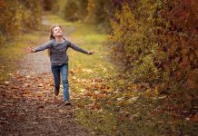 Caminos públicos Niña corriendo con brazos abiertos por camino